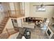 Open-concept living space features a staircase, living room, kitchen, and dining area with hardwood floors at 15122 Fillmore Way, Thornton, CO 80602