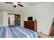 Primary bedroom with a barn door leading to closet and en suite, ceiling fan, and large dresser at 15122 Fillmore Way, Thornton, CO 80602
