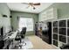 Well-lit office with carpet flooring, modern desk, shelving, and large window overlooking the yard at 15122 Fillmore Way, Thornton, CO 80602