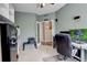 Home office with carpet, open shelving, modern desk, comfortable chair, and double door entry at 15122 Fillmore Way, Thornton, CO 80602