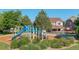 Neighborhood park with a blue play structure, mature trees, and a lovely two-story home in the background at 15122 Fillmore Way, Thornton, CO 80602