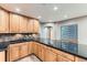 Charming kitchen with wood cabinets, dark countertops, and stylish tile backsplash at 15901 W 66Th Pl, Arvada, CO 80007