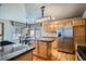 Well-lit kitchen with stainless steel appliances, island, and wood cabinets at 15901 W 66Th Pl, Arvada, CO 80007