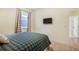 Cozy bedroom with a plaid comforter, curtains, and a mounted flat screen television at 2130 Indian Balsam Dr, Monument, CO 80132