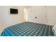 Bright bedroom featuring a plaid comforter, closet, and a mounted flat screen television at 2130 Indian Balsam Dr, Monument, CO 80132