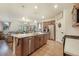 Open-concept kitchen with stainless steel appliances, center island with bar seating, and hardwood floors at 2130 Indian Balsam Dr, Monument, CO 80132