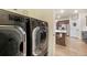 Dark gray front load washer and dryer, leading to the kitchen with island and stainless steel appliances at 2130 Indian Balsam Dr, Monument, CO 80132