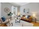 Bright living room with a brown couch, rounded wood decor, and large windows for ample natural light at 639 25Th St, Denver, CO 80205