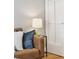 Living room with a brown couch, blue pillows, a lamp on a side table, and a white door at 639 25Th St, Denver, CO 80205