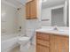 This bright bathroom features a shower-tub combo, toilet, and wooden vanity for a clean and comfortable design at 8406 Everett Way # C, Arvada, CO 80005