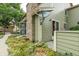 View of home's exterior with green siding, brick chimney, manicured ground cover, and a satellite dish at 8406 Everett Way # C, Arvada, CO 80005