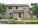 Inviting two-story townhome featuring a stone chimney and well-maintained landscaping at 8406 Everett Way # C, Arvada, CO 80005
