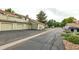 View of the townhouse with a three-car garage and street parking at 8406 Everett Way # C, Arvada, CO 80005