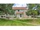 Charming home exterior with a stone chimney, lush lawn and landscaped front yard at 8406 Everett Way # C, Arvada, CO 80005