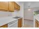 Bright kitchen with stainless steel sink, white appliances, and wood cabinets at 8406 Everett Way # C, Arvada, CO 80005