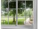 This window offers picturesque views of a lush yard, mature trees, and a sidewalk bordering green space at 8406 Everett Way # C, Arvada, CO 80005