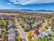 Expansive aerial view of a neighborhood nestled among colorful fall foliage and distant mountains at 1462 Hyacinth Way, Superior, CO 80027