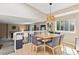 Bright dining area features a wood table, gray chairs, a wicker pendant light, and natural light from the nearby window at 1462 Hyacinth Way, Superior, CO 80027