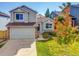 Inviting two-story home with an attached garage, set amidst a lush green lawn and colorful tree at 1462 Hyacinth Way, Superior, CO 80027