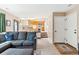 Comfortable living room features a gray sectional sofa, view of the kitchen, and a staircase leading to the upper level at 1462 Hyacinth Way, Superior, CO 80027