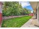 Lush backyard featuring a neatly manicured lawn, brick wall, and a red storage shed for added convenience at 13472 E Dakota Ave, Aurora, CO 80012