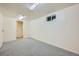 Finished basement area with cozy carpet, small window, and an easily accessible door for added convenience at 13472 E Dakota Ave, Aurora, CO 80012