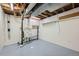 Utility area with exposed pipes and rafters, sink, storage cabinets, and durable painted floors at 13472 E Dakota Ave, Aurora, CO 80012