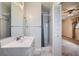 Renovated bathroom with tiled shower and vanity area adjacent to bedroom at 13472 E Dakota Ave, Aurora, CO 80012