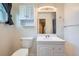 Bathroom features a mirror with vanity lights, wood look floor and shower at 13472 E Dakota Ave, Aurora, CO 80012