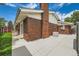 Brick home featuring a concrete patio, a well-kept lawn, and a red storage shed in the backyard at 13472 E Dakota Ave, Aurora, CO 80012