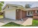 Close-up of the exterior showcasing the brickwork, garage door, pathway, and covered porch at 13472 E Dakota Ave, Aurora, CO 80012