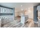 The kitchen seamlessly transitions into the living room featuring an island, modern appliances and white cabinetry at 13472 E Dakota Ave, Aurora, CO 80012
