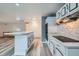Bright kitchen features white cabinets with marble countertops, stainless hood and island at 13472 E Dakota Ave, Aurora, CO 80012
