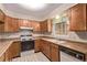 Efficient kitchen with wooden cabinetry, laminate countertops, and ample natural light at 309 Pheasant Run, Louisville, CO 80027