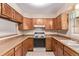 Functional kitchen featuring wooden cabinets, classic appliances, and tile backsplash at 309 Pheasant Run, Louisville, CO 80027