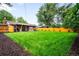 Well-maintained lawn surrounded by mature trees and a wooden fence at 1810 S Kearney St, Denver, CO 80224