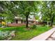 Charming tan home with brick, chimney, solar panels, tidy yard, and for sale sign at 1810 S Kearney St, Denver, CO 80224