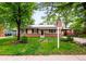 Charming tan home with brick, chimney, solar panels, tidy yard, and for sale sign at 1810 S Kearney St, Denver, CO 80224