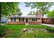 Charming tan home with brick, chimney, solar panels, tidy yard, and covered car port at 1810 S Kearney St, Denver, CO 80224