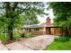 Charming tan home with brick, chimney, solar panels, tidy yard, long driveway, and covered car port at 1810 S Kearney St, Denver, CO 80224