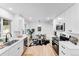 Bright kitchen features white cabinets, stainless steel appliances, and an adjacent dining area for seamless living at 1810 S Kearney St, Denver, CO 80224