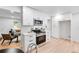 Modern kitchen with white cabinets, stainless steel appliances, and sleek countertops adjacent to cozy living area at 1810 S Kearney St, Denver, CO 80224