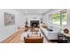 Bright living room featuring hardwood floors, a fireplace, a sofa, and ample natural light at 1810 S Kearney St, Denver, CO 80224