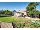 Spacious back yard featuring a patio set, lawn, landscaping, and vegetable garden at 10482 Billings St, Commerce City, CO 80022