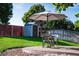 Well-maintained backyard featuring lush lawn, privacy fence, storage shed, and patio seating area with umbrella at 10482 Billings St, Commerce City, CO 80022