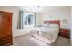 Comfortable bedroom featuring a large window with sunlit view, wood furnishings, and neutral carpet at 10482 Billings St, Commerce City, CO 80022