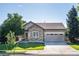 Charming single-story home features a stone facade, well-manicured lawn, and an attached two-car garage at 10482 Billings St, Commerce City, CO 80022