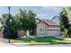 Beautiful home exterior featuring stone accents, a green lawn, mature trees, and an attached two-car garage at 10482 Billings St, Commerce City, CO 80022