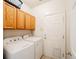 Functional laundry room featuring a washer, dryer, storage cabinets, and exterior access door at 10482 Billings St, Commerce City, CO 80022