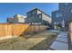 This backyard has a wooden fence with a small patch of grass, a patio with seating, and the back of the home at 4117 Quivas St, Denver, CO 80211